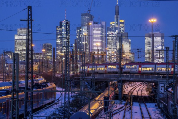 Railway tracks in front of the main railway station in Frankfurt am Main, skyline of skyscrapers in the Cit, winter, snow, dusk, Hesse, North Rhine-Westphalia