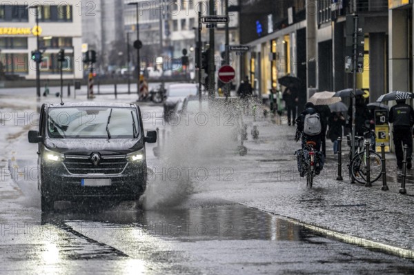 Winter, rainy weather, freezing rain, large puddle, puddle of water, in the city centre, Große Gallusstraße, vehicles driving through, spraying water fountains, Frankfurt am Main, Hesse, Germany, Europe