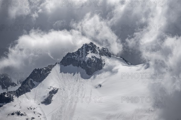 Dramatic clouds, rocky mountain peak with snow and glacier Waxeggkees, Berliner Höhenweg, Zillertal Alps, Tyrol, Austria, Europe