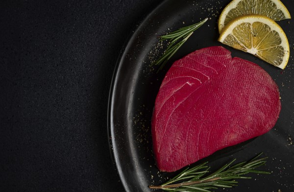 Fresh red tuna fillet, for steak, raw, top view, on a black plate, no people