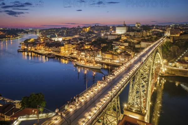View of illuminated Porto city and Douro river and Dom Luis bridge I from famous tourist viewpoint Miradouro da Serra do Pilar in evening twilight. Porto, Vila Nova de Gaia, Portugal, Europe