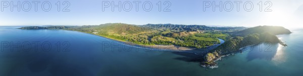 Panoramic aerial view of a green forested coastal landscape with blue sea and sky, Pochote, Puntarenas, Costa Rica, Central America