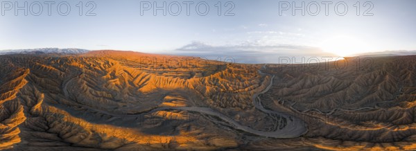 Panorama, riverbed runs through a landscape of eroded hills, badlands at sunrise, Issyk Kul Lake in the background, aerial view, Canyon of the Forgotten Rivers, Issyk Kul, Kyrgyzstan, Asia