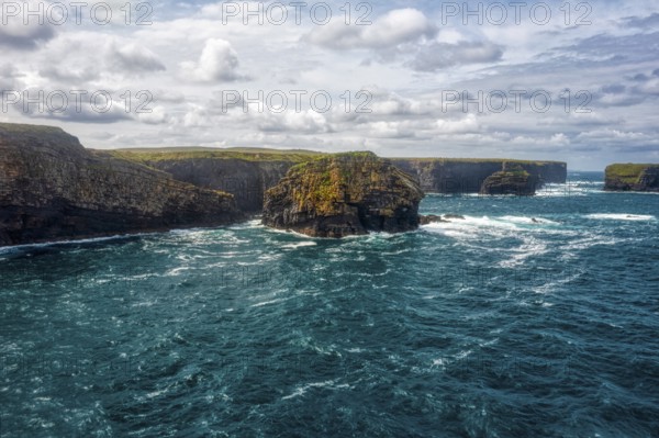 Picturesque coastal scenery with deep blue sea, dramatic cliffs and cloudy skies, Kilkee