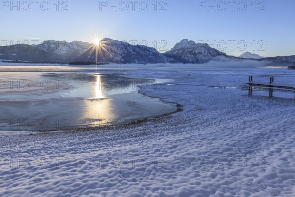 Sunrise at a lake in front of mountains, footbridge, snow, winter, Forggensee, Königswinkel, view of Tegelberg and Säuling, Alpine foothills, Upper Bavaria, Bavaria, Germany, Europe