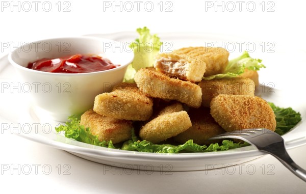 Fried chicken breast nuggets, on lettuce leaves, with tomato sauce, horizontal, no people, selective focus
