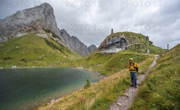 Mountaineer on hiking trail at Wolayersee, Alpine Club hut Wolayerseehütte, rocky cloudy mountains, Carnic Alps, Carnic High Trail, Carinthia, Austria, Europe