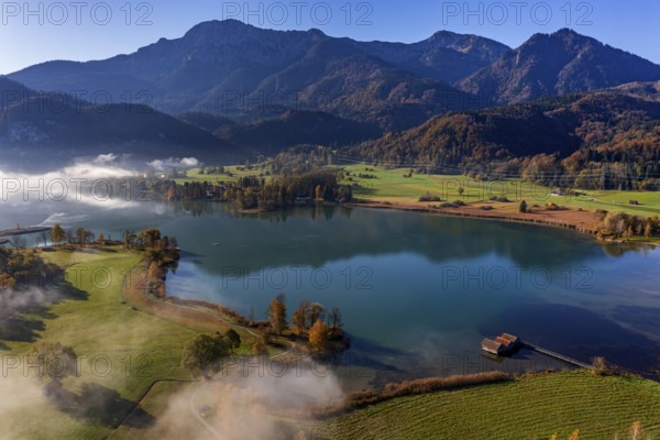 Aerial view of a lake in front of mountains in autumn, midday light, view of Herzogstand and Heimgarten, Lake Kochel, foothills of the Alps, Bavaria, Germany, Europe