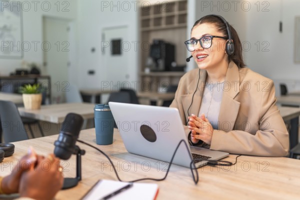 Two podcasters are recording a new episode in a modern studio, using professional equipment like microphones and headphones