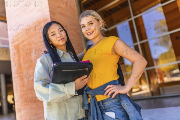 Portrait of multi-ethnic female students outside the university building smiling at camera together