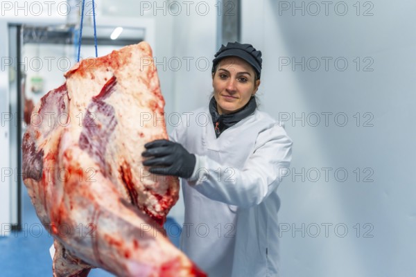 Female confident butcher working at the slaughter house sorting meat