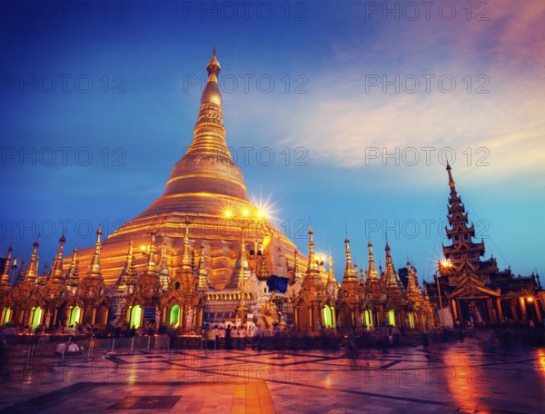 Vintage retro effect filtered hipster style image of Myanmer famous sacred place and tourist attraction landmark, Shwedagon Paya pagoda illuminated in the evening. Yangon, Myanmar Burma