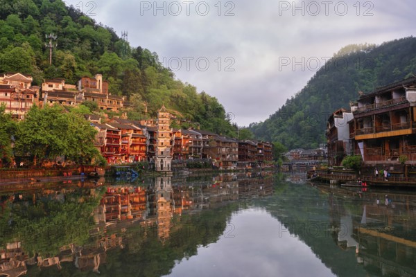 Chinese tourist attraction destination, Feng Huang Ancient Town (Phoenix Ancient Town) on Tuo Jiang River with Wanming Pagoda tower on sunset. Hunan Province, China, Asia