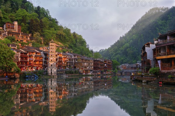 Chinese tourist attraction destination, Feng Huang Ancient Town (Phoenix Ancient Town) on Tuo Jiang River with Wanming Pagoda tower on sunset. Hunan Province, China, Asia