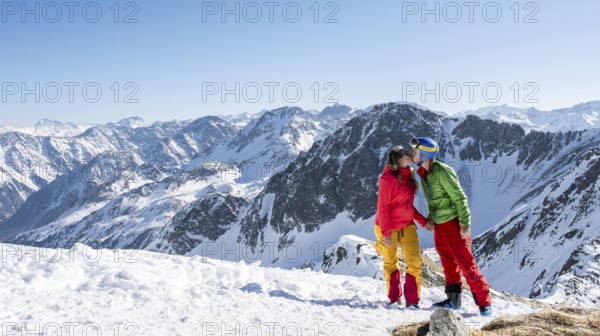 Ski tourer standing next to summit cross, summit of Mitterzeigerkogel in winter, Sellraintal, Kühtai, Tyrol, Austria, Europe