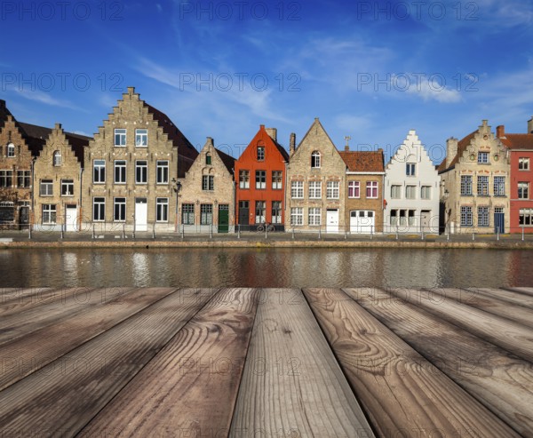 Wooden planks table with typical European Europe cityscape view, canal and medieval houses in background. Brugge, Belgium, Europe