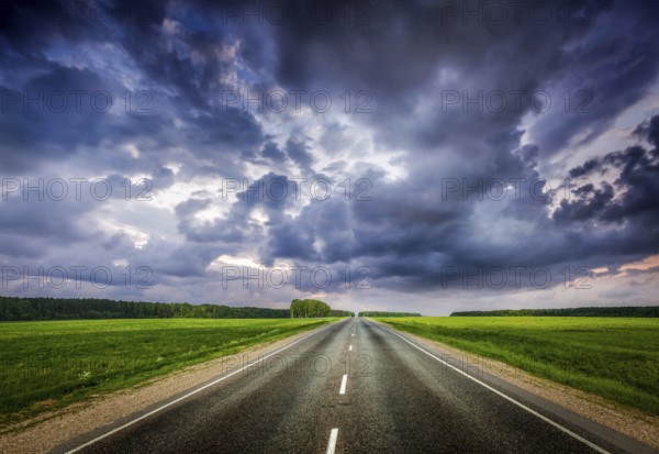 Travel concept background, road and stormy dramatic sky
