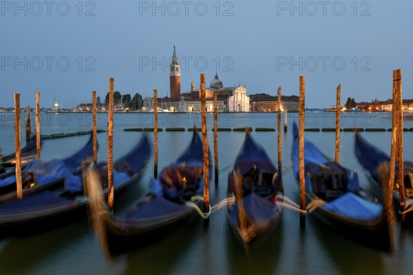 Venetian gondolas near St. Mark's Square in the evening light, blue hour, in the background the monastery of San Giorgio Maggiore, district of San Marco, Venice, Veneto region, Italy, Europe