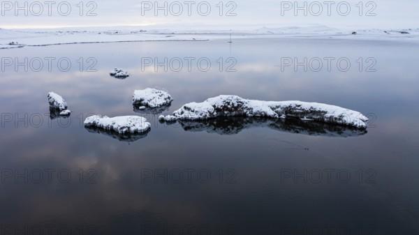 Snow-covered small islands overgrown with bushes in Lake Myvatn, at blue hour, Kalfaströnd, drone shot, Northern Iceland Eyestra, Iceland, Europe