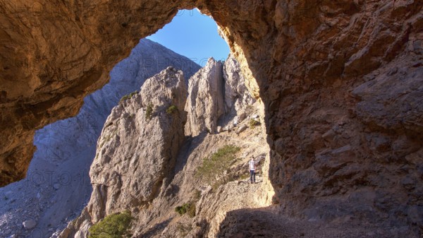Rock gate, hikers on hiking trail, Gingilos, hiking on the Gingilos, morning light, cloudless blue sky, Samaria Gorge, Omalos, Lefka Ori, White Mountains, West Crete, island of Crete, Greece, Europe