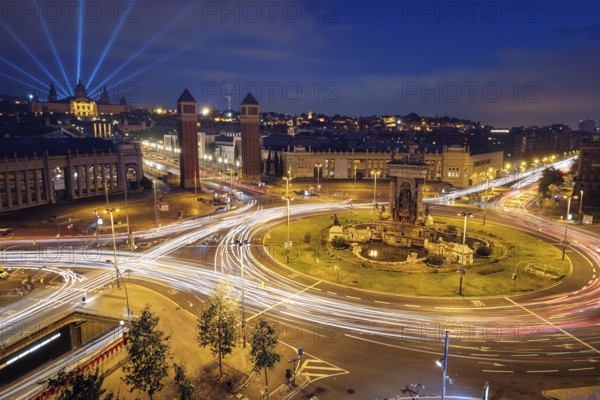 View Placa d'Espanya, Plaza de Espana, the Spanish Square in Barcelona, Catalonia, Spain with city traffic in the evening blue hour with light trails