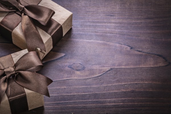 Two vintage gift boxes covered crumpled paper with copyspace on old wooden board holiday concept
