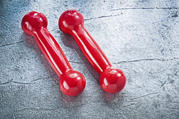 Pair of red dumbbells on silver surface fitness concept