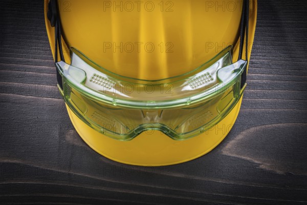 Safety glasses and building helmet on vintage wooden board