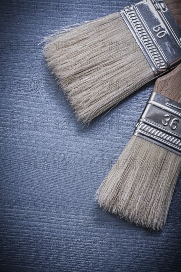 Paintbrushes on wooden board vertical version construction concept