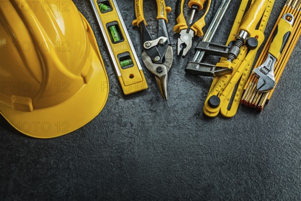 Set of yellow construction tools on black background
