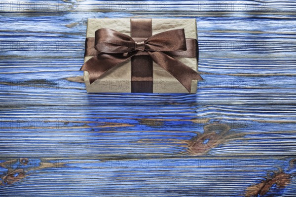 Wrapped brown present box on vintage wooden board