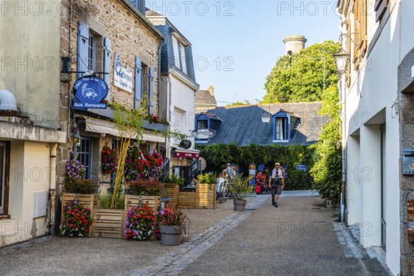 Pont-Aven, France, August 5, 2018: Picturesque street in the walled medieval town. Sunny day against blue sky. Finistere, Brittany, France, Europe