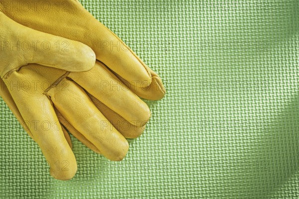 Leather safety gloves on green background construction concept