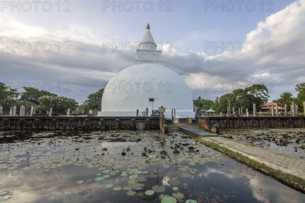 Landscape photography in a subtropical climate. Lagoon or marshland by a lake, evening shot with temple at Kiriibban Wewa in southern Sri Lanka