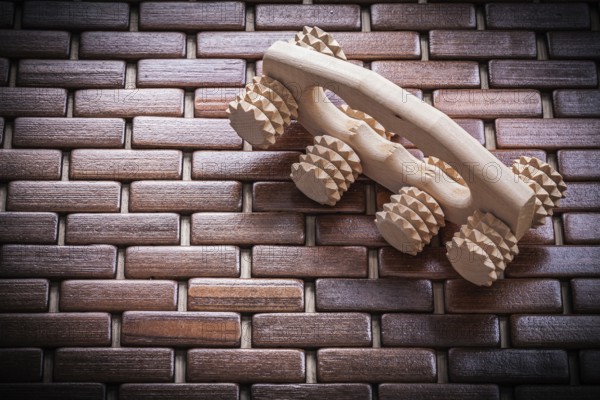 Wood massager on checked wooden matting healthcare concept