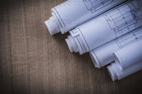 Heap of rolled blueprints on wood board construction concept
