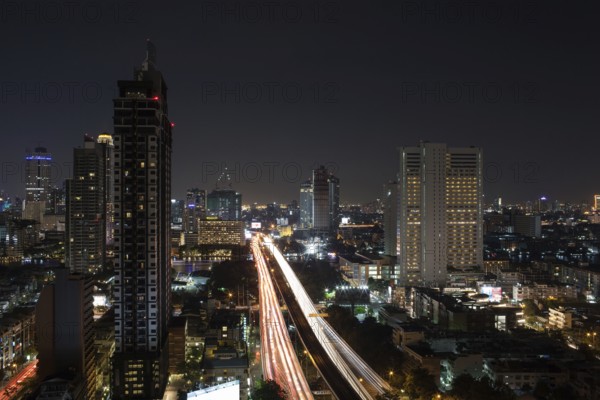 Night cityscape of Bangkok, Thailand capital. View to the illuminated buildings and busy motorway