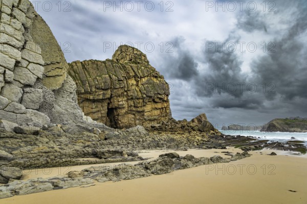 Powerful surf waves with a foam crest. Cantabria. Windy stormy day on the Atlantic coast. Rocky picturesque ocean coast. Noon on the beach of Playa di Arnia, Spain, Europe