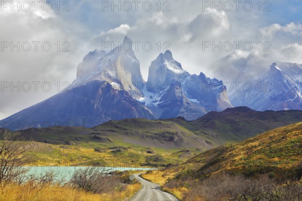 Summer day in the national park Torres del Paine, Patagonia, Chile. A dirt road leads to the cliffs of Los Kuernos