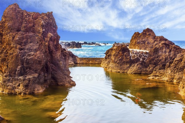 Rocks of the Atlantic coast. The concept of exotic and ecological tourism. Volcanic island of Madeira. Small bay with smooth water on beautiful coast