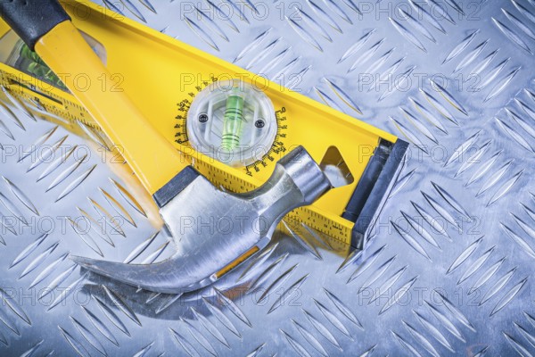 Claw hammer construction level on grooved metal plate