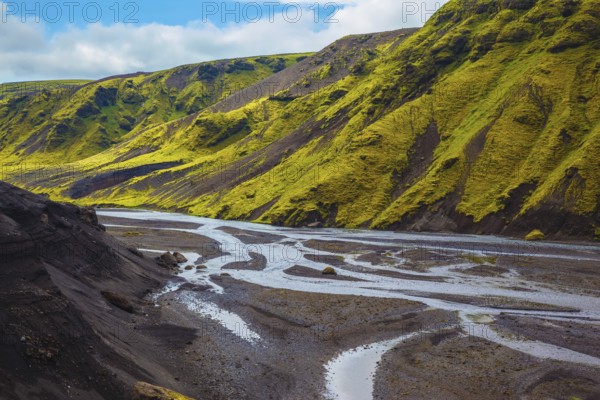 Canyon Pakgil in Iceland. Picturesque basalt hills covered with green grass and moss-polar. Streams from melting glaciers flowing down the canyon