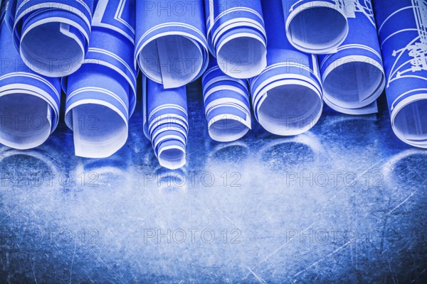 Blue blueprints on metallic background directly above construction concept