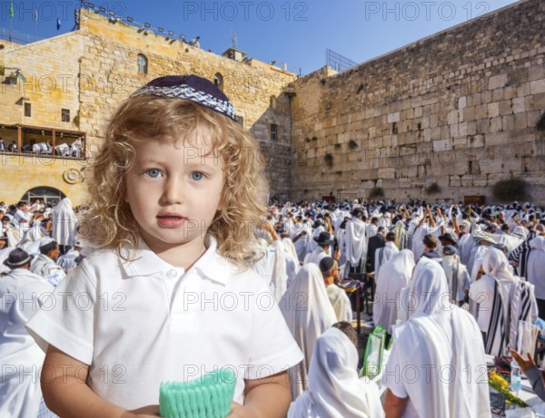 Llittle Jewish boy with side curls in yarmulke. Jews praying at the Western Wall. Ceremony at the Temple Mount in Jerusalem. The blessing of Cohenim.the concept of religious and photo tourism