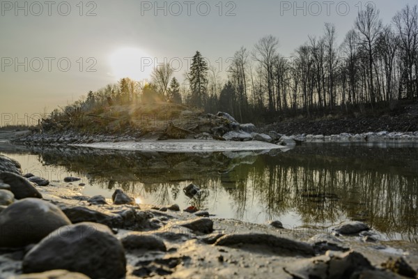 Sunset by the river with spectacular reflections and bare trees, Saalach, Austria, Europe