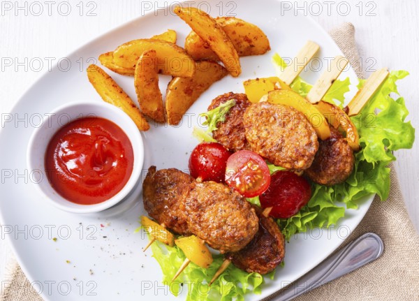 Meatballs skewers of tomato, paprika and baked potato quarters