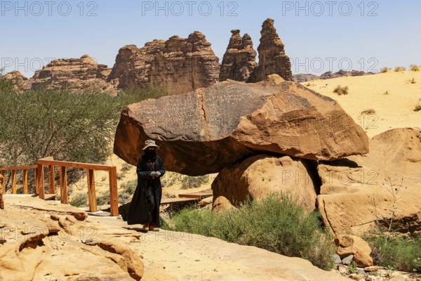 Guide in Jebel or Jabal Ikmah shows large open library, rock bands with petroglyphs, rock carvings in open-air museum, Dadan, sandstone, Al Ula, Saudi Arabia, Asia