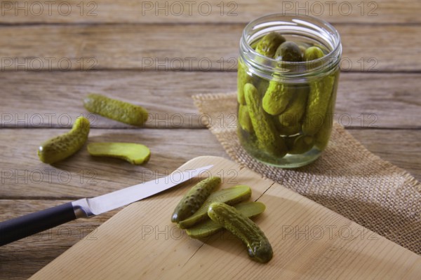 Bottled pickles cucumbers in vintage wooden table