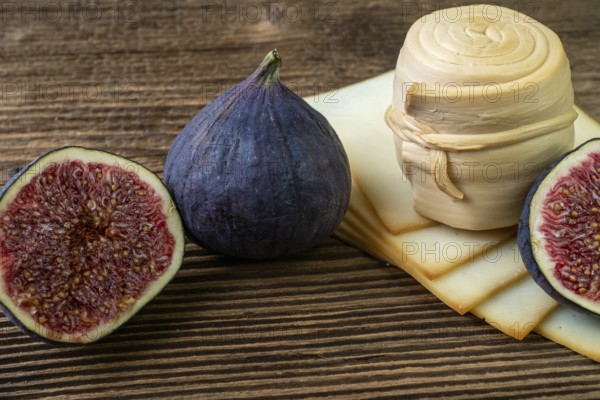 Figs, various cheese on a rustic table.Traditional hand made slovak smoked cheese parenica. Healthy eating concept