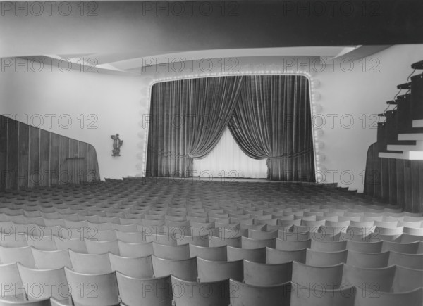 Cinema in the 1940s. An interior of a typical looking movie theatre with seats near the film screen and on the balcony. The screen is covered partly by drapes. Sweden 1940s